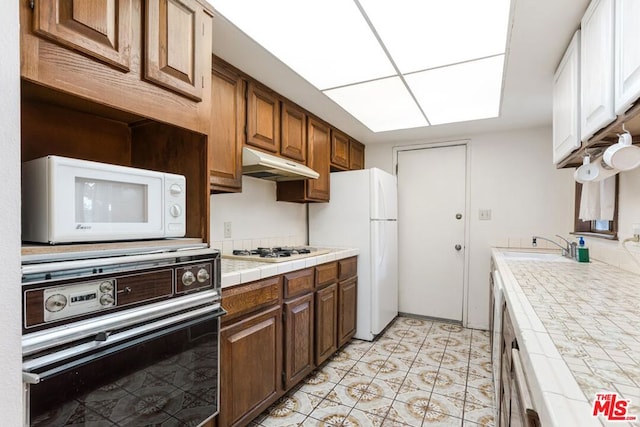 kitchen with tile countertops and white appliances