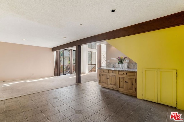 interior space with beam ceiling and a textured ceiling