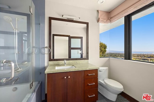 full bathroom with tile patterned floors, vanity, toilet, and shower / bath combination with glass door