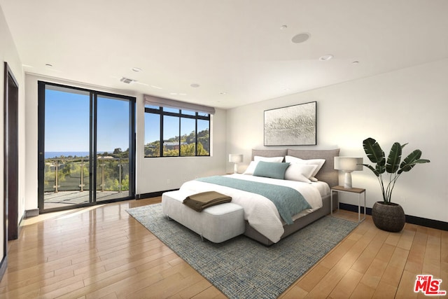 bedroom featuring floor to ceiling windows, access to exterior, and light hardwood / wood-style flooring