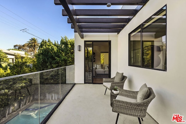 view of patio / terrace featuring a balcony and a fenced in pool