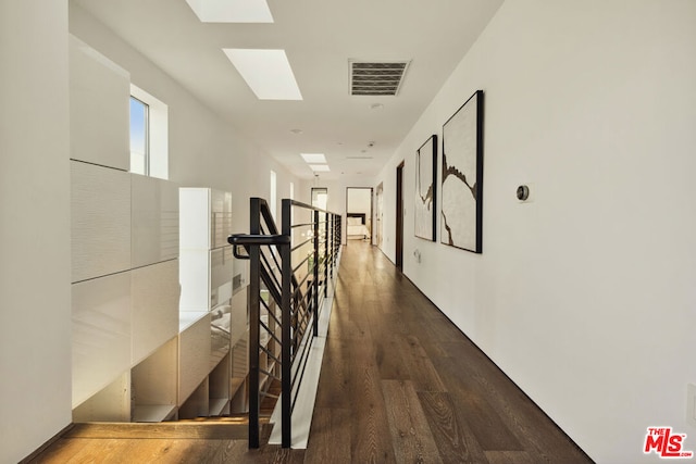 hall featuring dark hardwood / wood-style flooring and a skylight