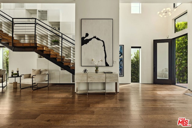 entrance foyer featuring a high ceiling, dark hardwood / wood-style flooring, and an inviting chandelier