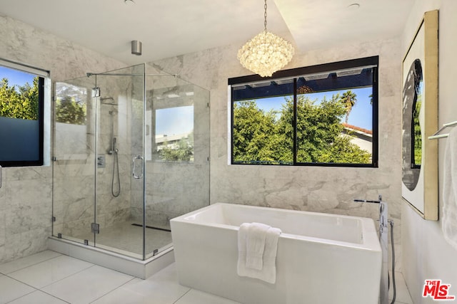 bathroom featuring tile patterned flooring, separate shower and tub, and an inviting chandelier