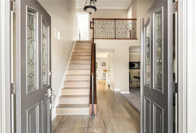 entryway featuring hardwood / wood-style floors and crown molding