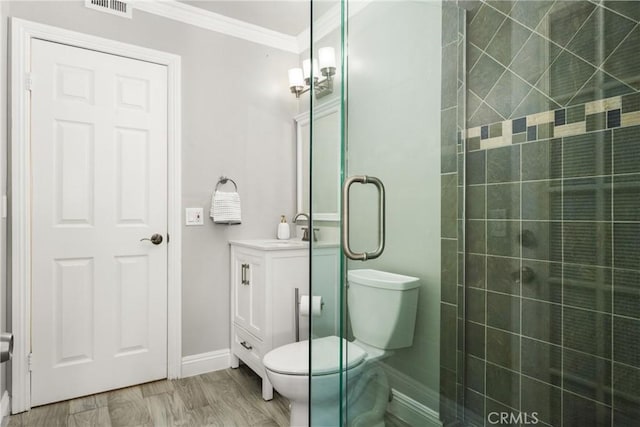 bathroom with vanity, wood-type flooring, toilet, ornamental molding, and a shower with shower door