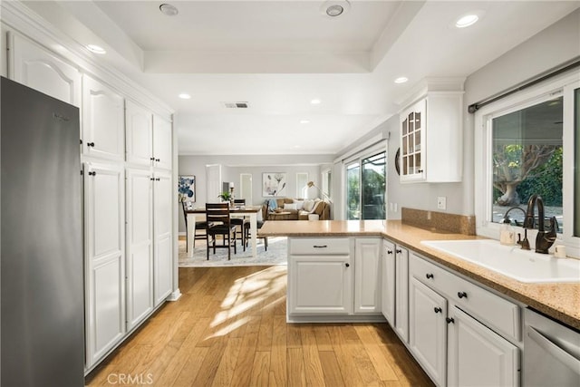 kitchen featuring kitchen peninsula, sink, white cabinets, and appliances with stainless steel finishes