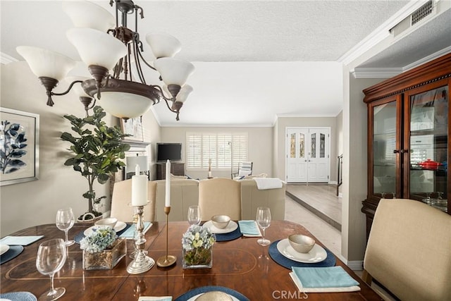 dining space with crown molding, hardwood / wood-style floors, a chandelier, and a textured ceiling