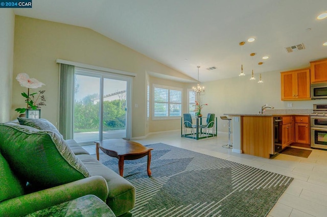 living room featuring light tile patterned flooring, a chandelier, and lofted ceiling