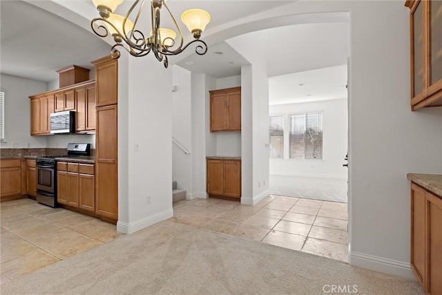 kitchen with light carpet, black gas range oven, decorative light fixtures, and a notable chandelier