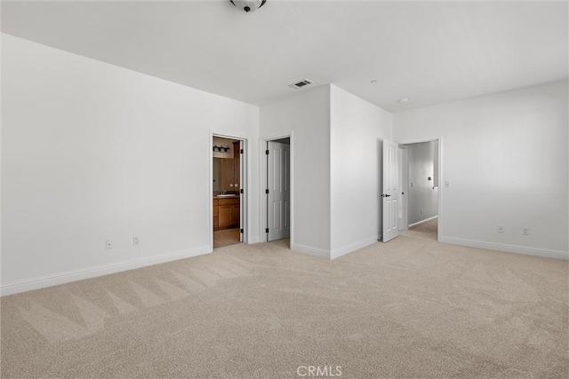 unfurnished bedroom with light carpet and ensuite bath