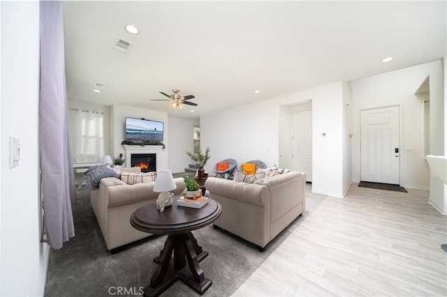 living room featuring ceiling fan and light hardwood / wood-style flooring