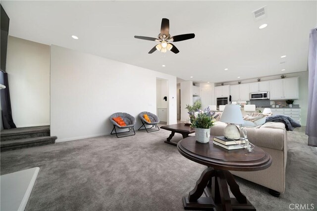 carpeted living room featuring ceiling fan