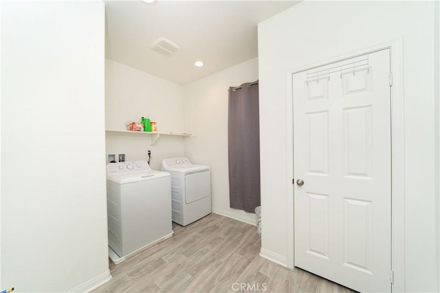 laundry room featuring light hardwood / wood-style floors and washing machine and clothes dryer