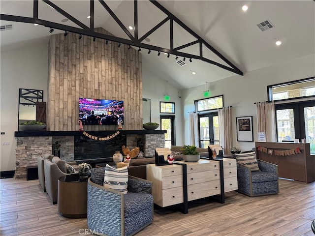 living room with hardwood / wood-style flooring, high vaulted ceiling, and french doors