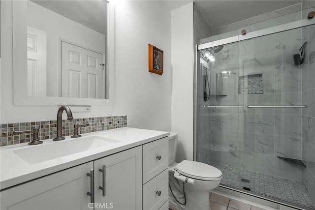 bathroom with vanity, a shower with door, backsplash, tile patterned floors, and toilet