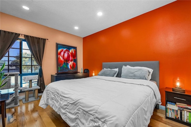 bedroom featuring a textured ceiling and light hardwood / wood-style floors