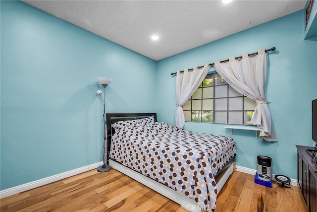 bedroom with light hardwood / wood-style flooring and a textured ceiling