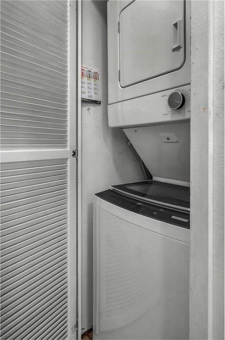 clothes washing area with stacked washer and clothes dryer