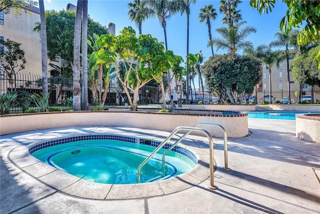 view of swimming pool with a hot tub