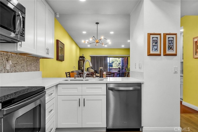 kitchen featuring an inviting chandelier, sink, hanging light fixtures, white cabinetry, and stainless steel appliances