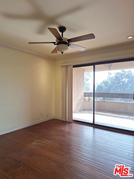 unfurnished room with ceiling fan, dark hardwood / wood-style flooring, and crown molding