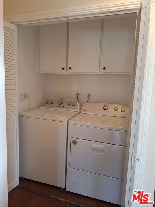 washroom with cabinets and washing machine and clothes dryer