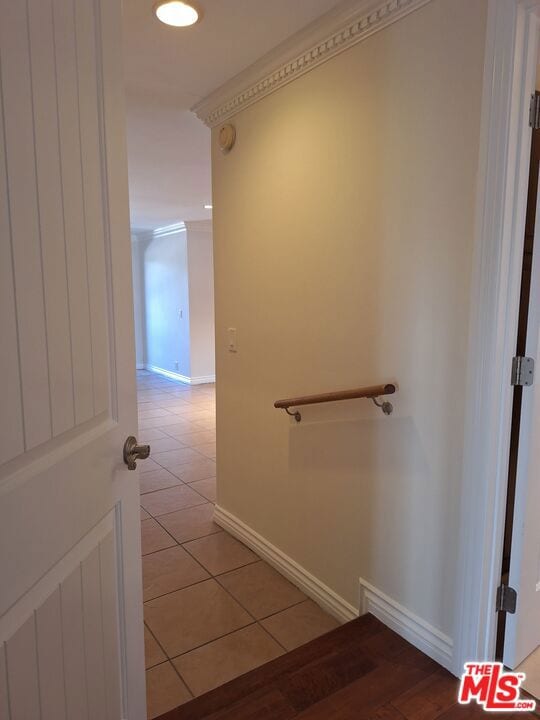 stairway with tile patterned flooring and ornamental molding