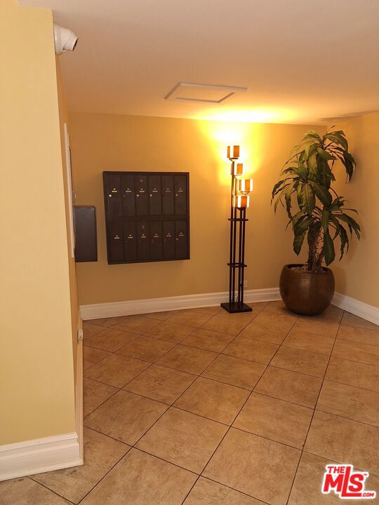 hallway featuring mail boxes and light tile patterned floors