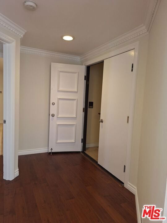 corridor with dark wood-type flooring and ornamental molding