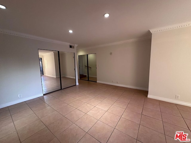 empty room featuring light tile patterned floors and ornamental molding