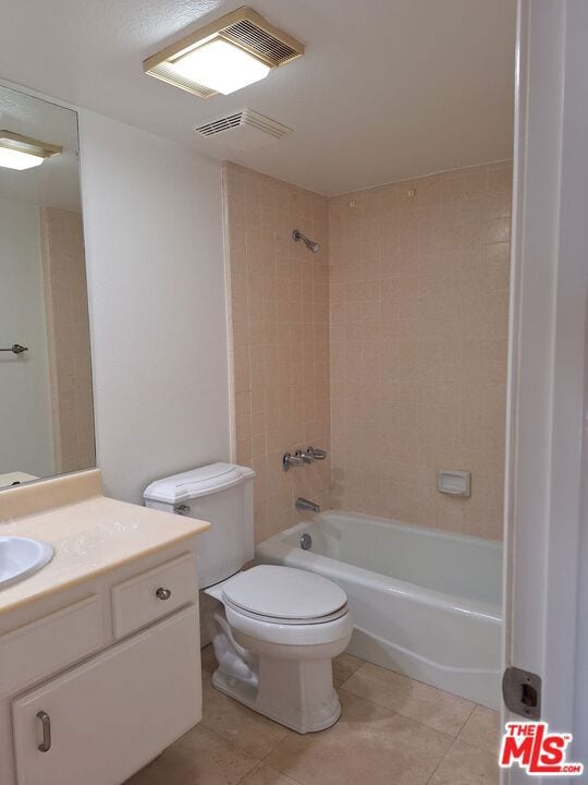 full bathroom featuring toilet, tile patterned flooring, tiled shower / bath combo, and vanity