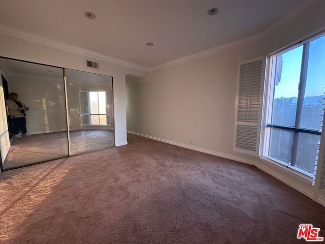 unfurnished bedroom featuring carpet floors, multiple windows, a closet, and ornamental molding