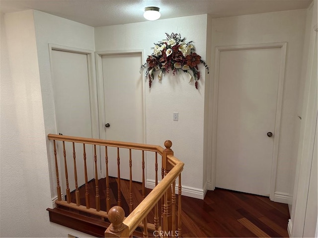 hallway featuring dark wood-style floors and an upstairs landing