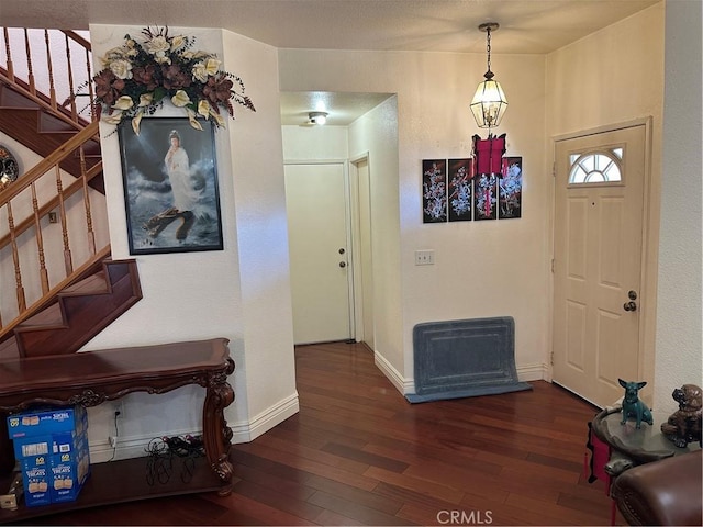 foyer entrance with stairs, hardwood / wood-style flooring, and baseboards