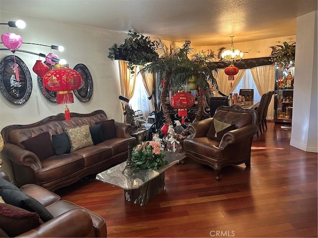 living room featuring a textured ceiling, wood finished floors, and a notable chandelier