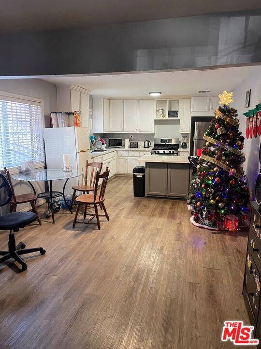 kitchen featuring white cabinetry, light wood-type flooring, and appliances with stainless steel finishes