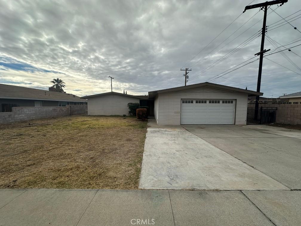 ranch-style home with a front yard and an outbuilding