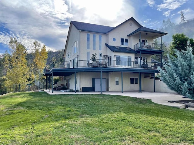 back of house with a yard, a balcony, and a patio