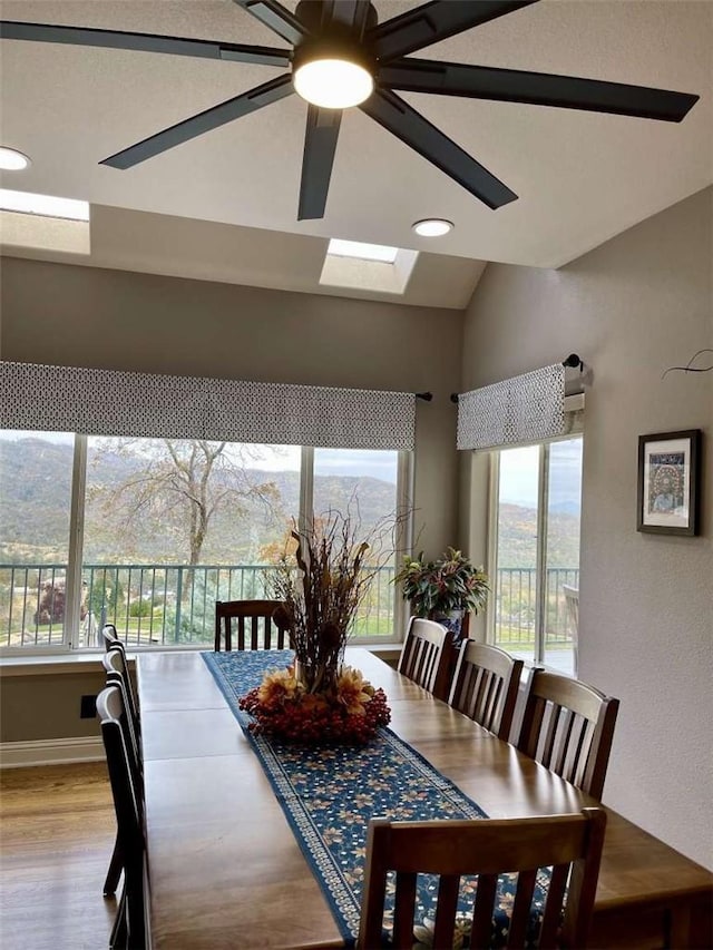 dining area featuring plenty of natural light, light hardwood / wood-style floors, a mountain view, and ceiling fan