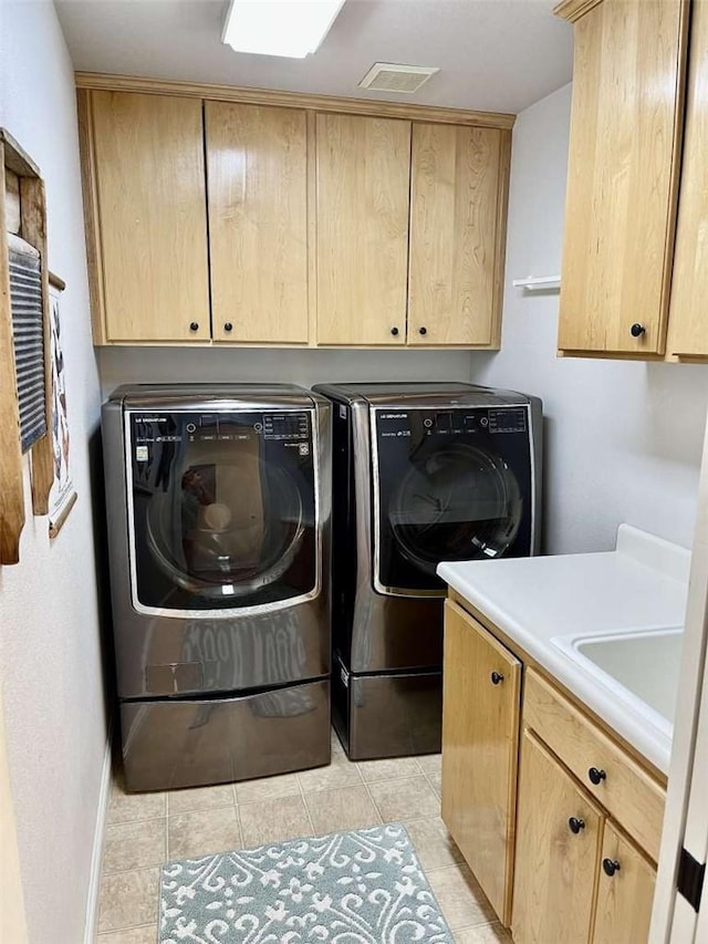 clothes washing area with cabinets, independent washer and dryer, sink, and light tile patterned flooring