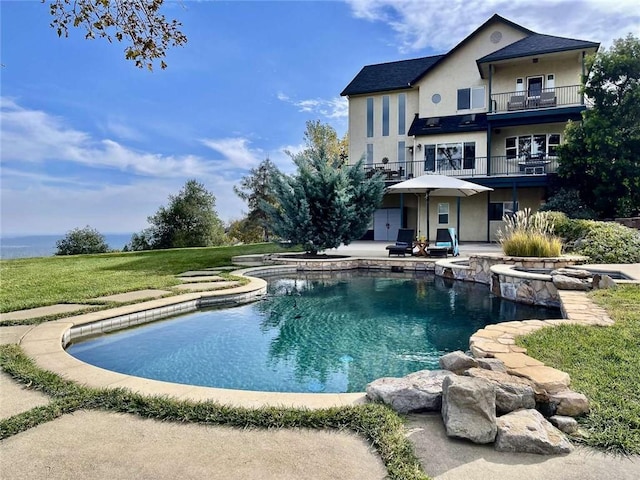 15223 Ledgewood Dr, Redding, CA 96001 - back of house featuring a lawn, an outdoor pool, a balcony, a patio, and stucco siding
