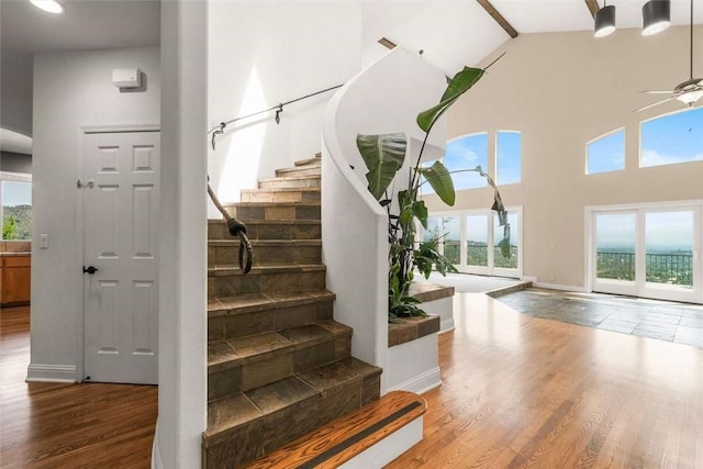 15223 Ledgewood Dr, Redding, CA 96001 - staircase with plenty of natural light, high vaulted ceiling, a ceiling fan, wood finished floors, and baseboards