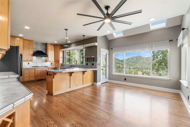 15223 Ledgewood Dr, Redding, CA 96001 - kitchen featuring black appliances, a ceiling fan, a breakfast bar, tasteful backsplash, and recessed lighting