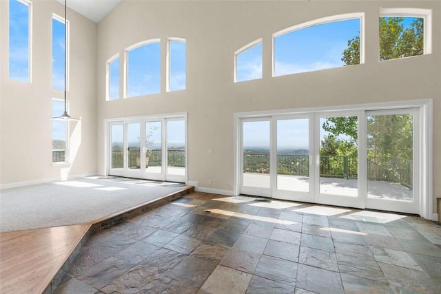 15223 Ledgewood Dr, Redding, CA 96001 - entryway with a high ceiling, baseboards, stone tile floors, healthy amount of natural light, and french doors