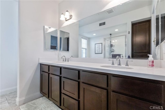 bathroom with tile patterned flooring, vanity, and walk in shower