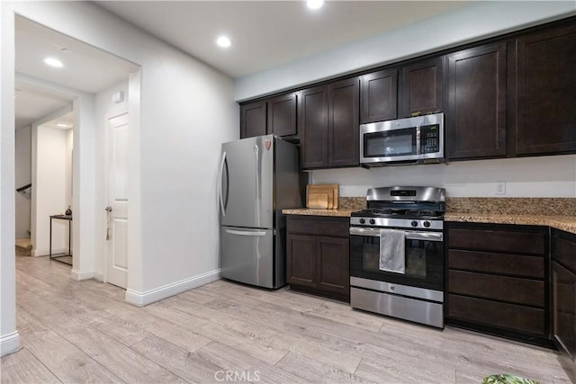 kitchen with dark brown cabinetry, light hardwood / wood-style flooring, and appliances with stainless steel finishes