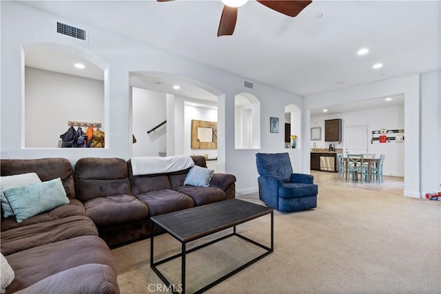 carpeted living room with ceiling fan