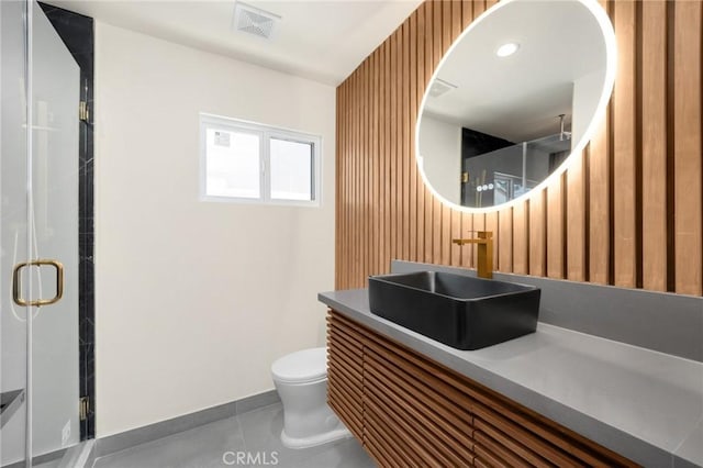 bathroom with tile patterned floors, vanity, toilet, and walk in shower