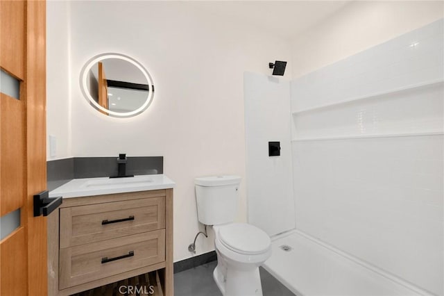 bathroom with vanity, toilet, and a shower